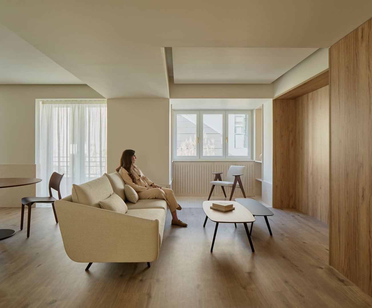 Zona de estar del apartamento Calasanz con sofá y paramentos de madera