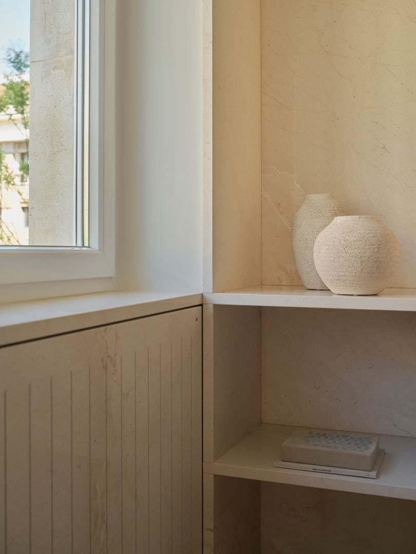 Ventana y estantería de madera con jarrones en el apartamento Calasanz