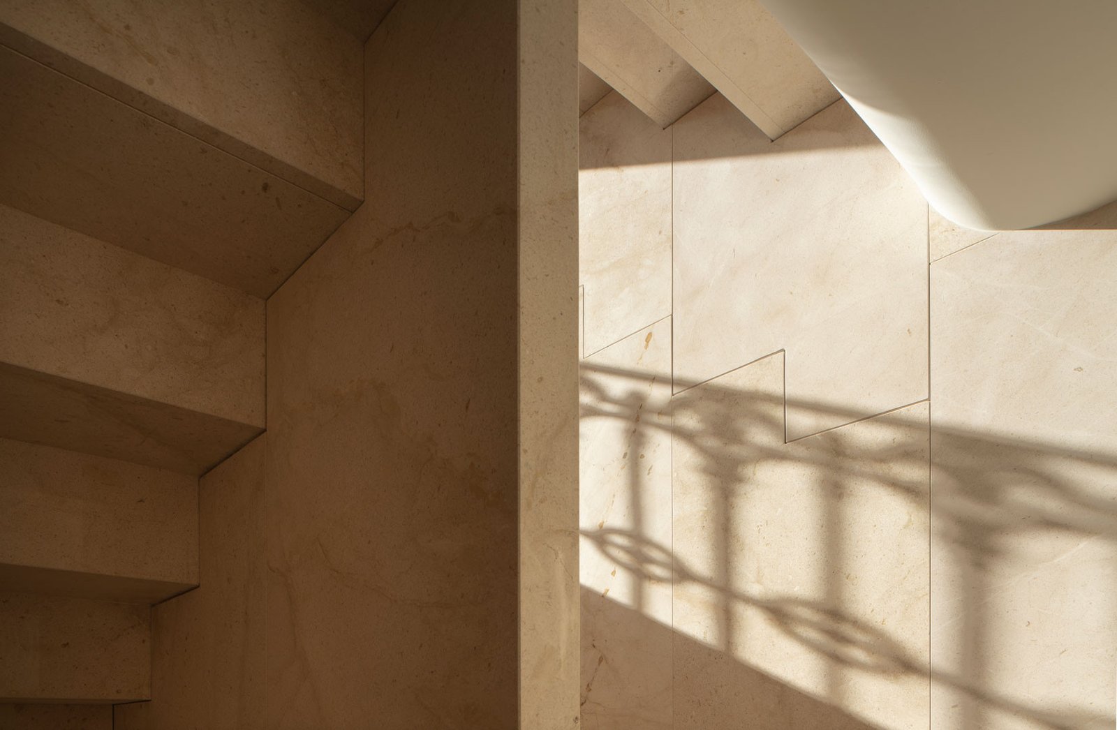 Escalera de la Casa de los Gigantes con la sombra de la rejería sobre el muro