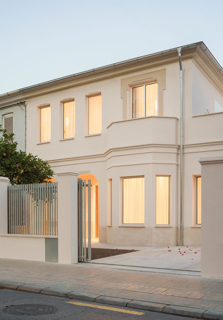 Fachada de la Casa del Limonero al atardecer, con el mirador y los huecos iluminados