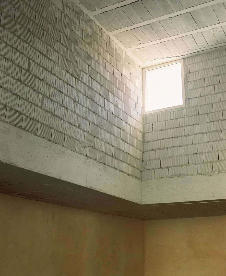 Detalle del interior a doble altura con bloque cerámico y estructura expuestos en Casa Latente