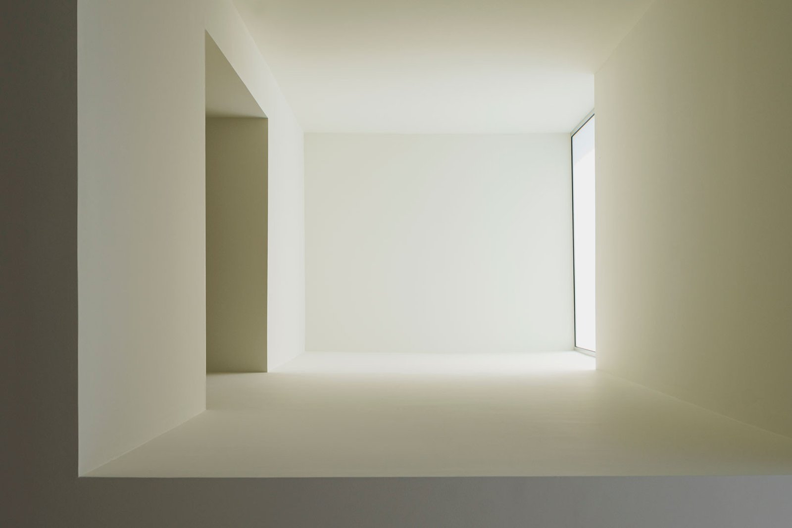 Estancia de Casa Mirasol con una amplia ventana y luz difusa sobre paramentos blancos