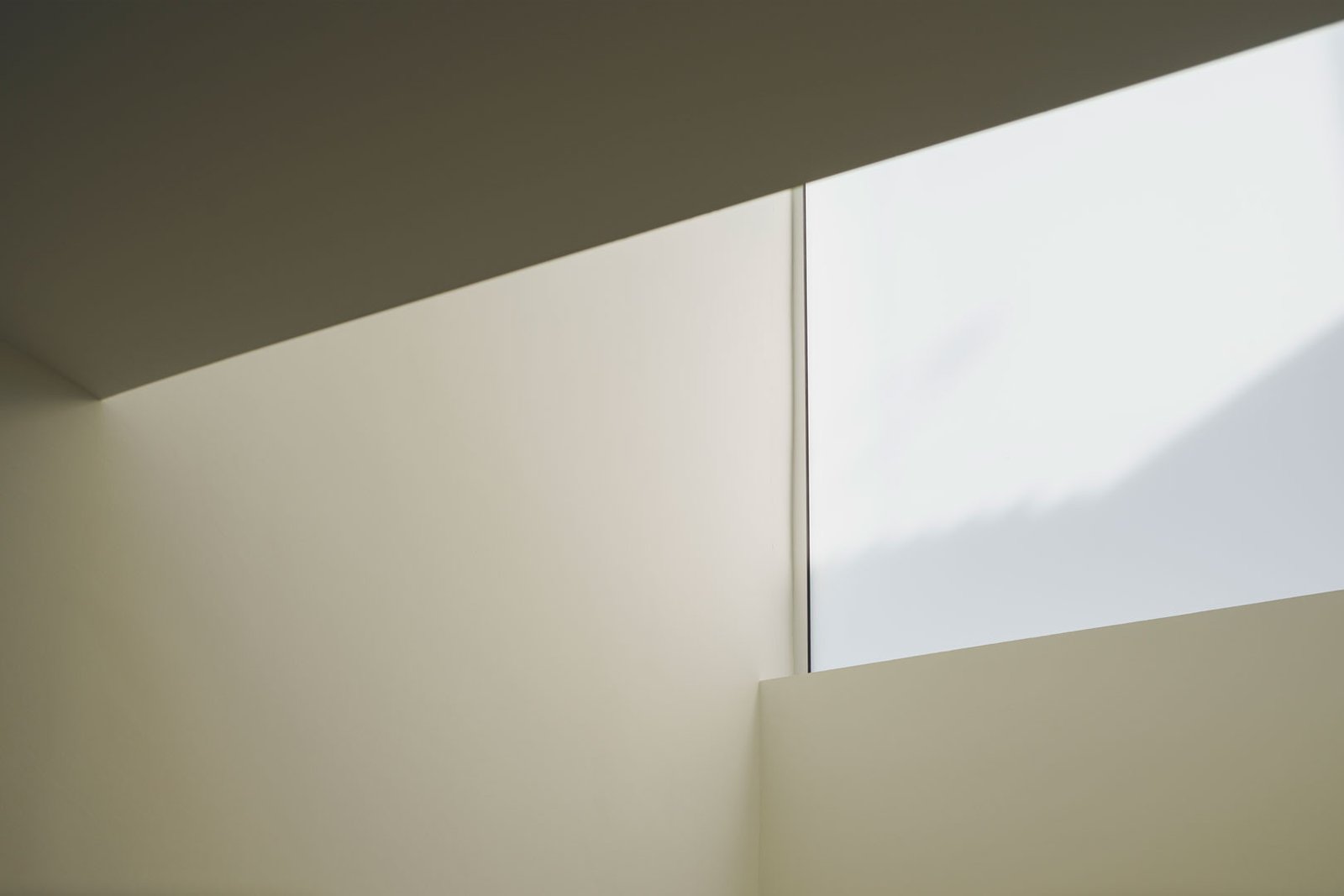 Muro blanco y ventana alta de Casa Mirasol con luz difusa