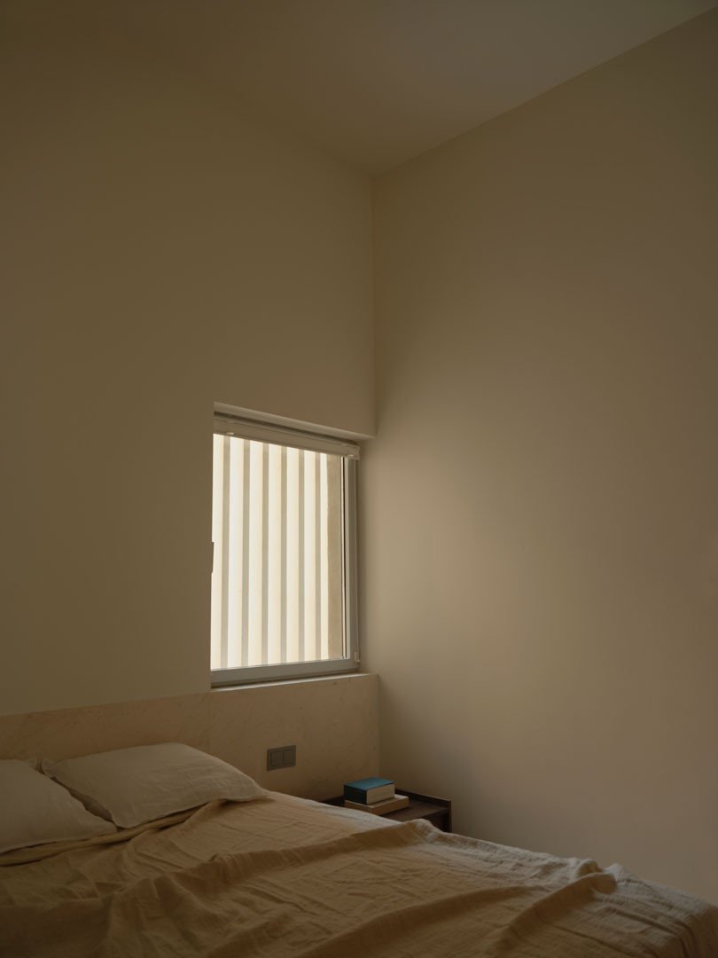 Dormitorio de Casa Nido con ventana pequeña y luz cálida