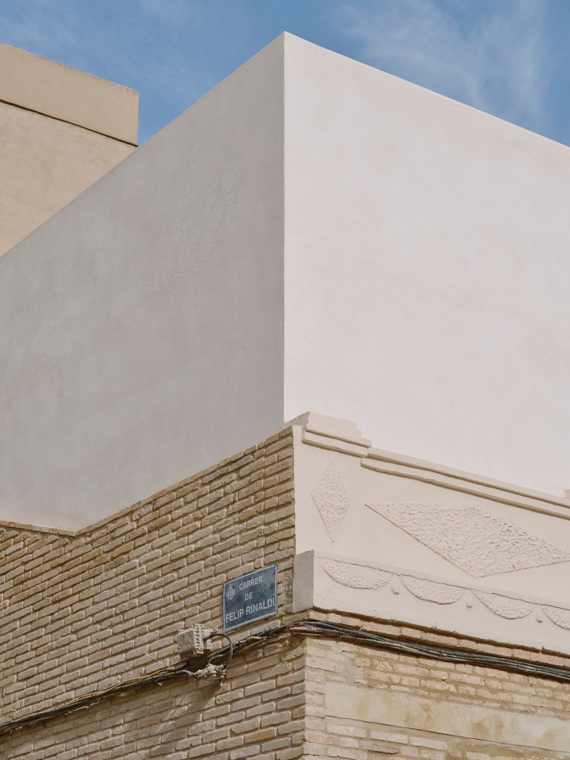 Volumen nuevo enlucido en cal sobre el muro de ladrillo y el friso original de Casa Nido