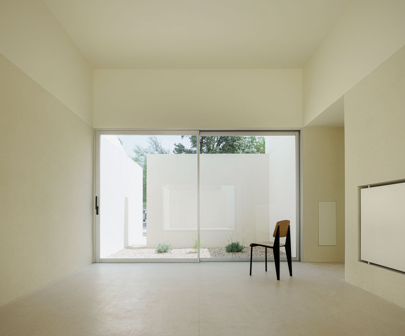 Sala de la Escuela en Aguas Nuevas con una silla frente al ventanal del patio