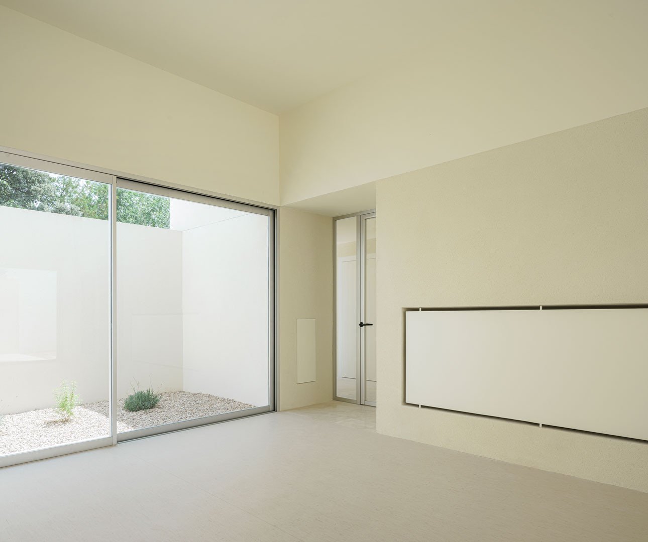 Sala de la Escuela en Aguas Nuevas abierta al patio con un gran ventanal